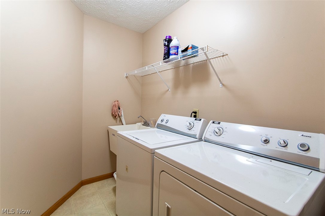 4902 Foote Road, Unit 21 Medina, OH 44256 - Photo 13 of 34 Laundry area with sink, a textured ceiling, washing machine and dryer, and light tile floors