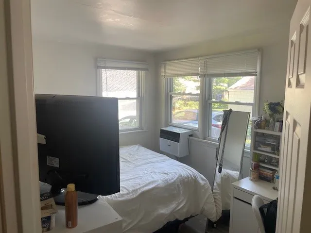 a bedroom with a bed and large windows