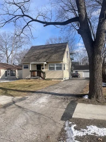 a view of a house with a tree next to a road