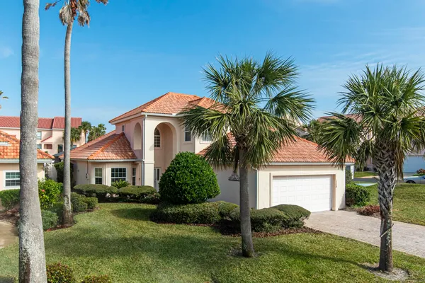 a front view of a house with a garden and yard
