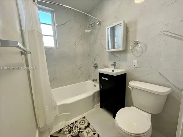 a white toilet sitting next to a bath tub