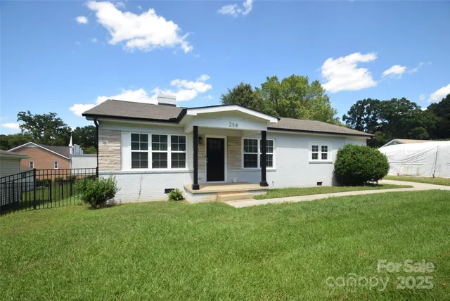 a front view of a house with a garden and yard