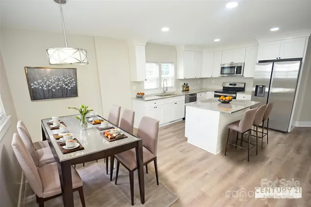 a kitchen with a dining table chairs refrigerator and microwave