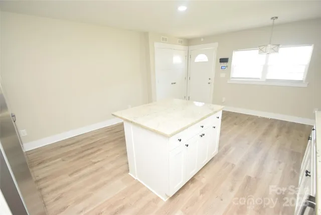 a view of a hallway with wooden floor and cabinet