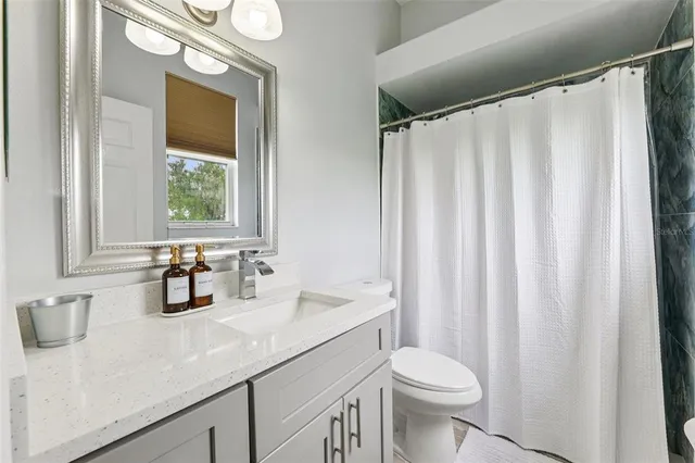 a bathroom with a double vanity sink toilet and a mirror