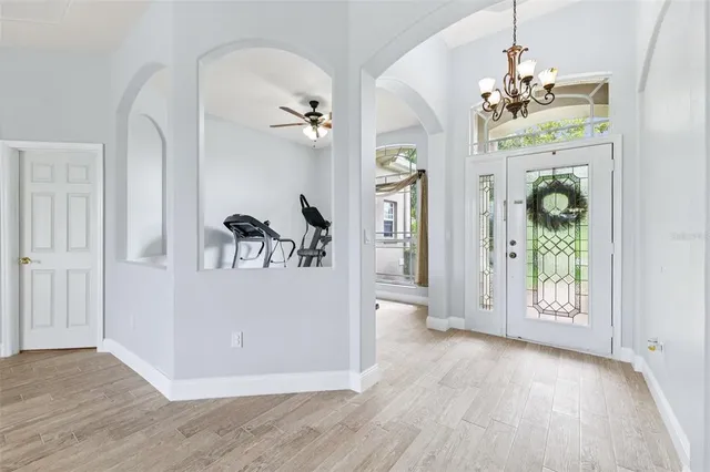 a view of a hallway view with wooden floor and chandelier