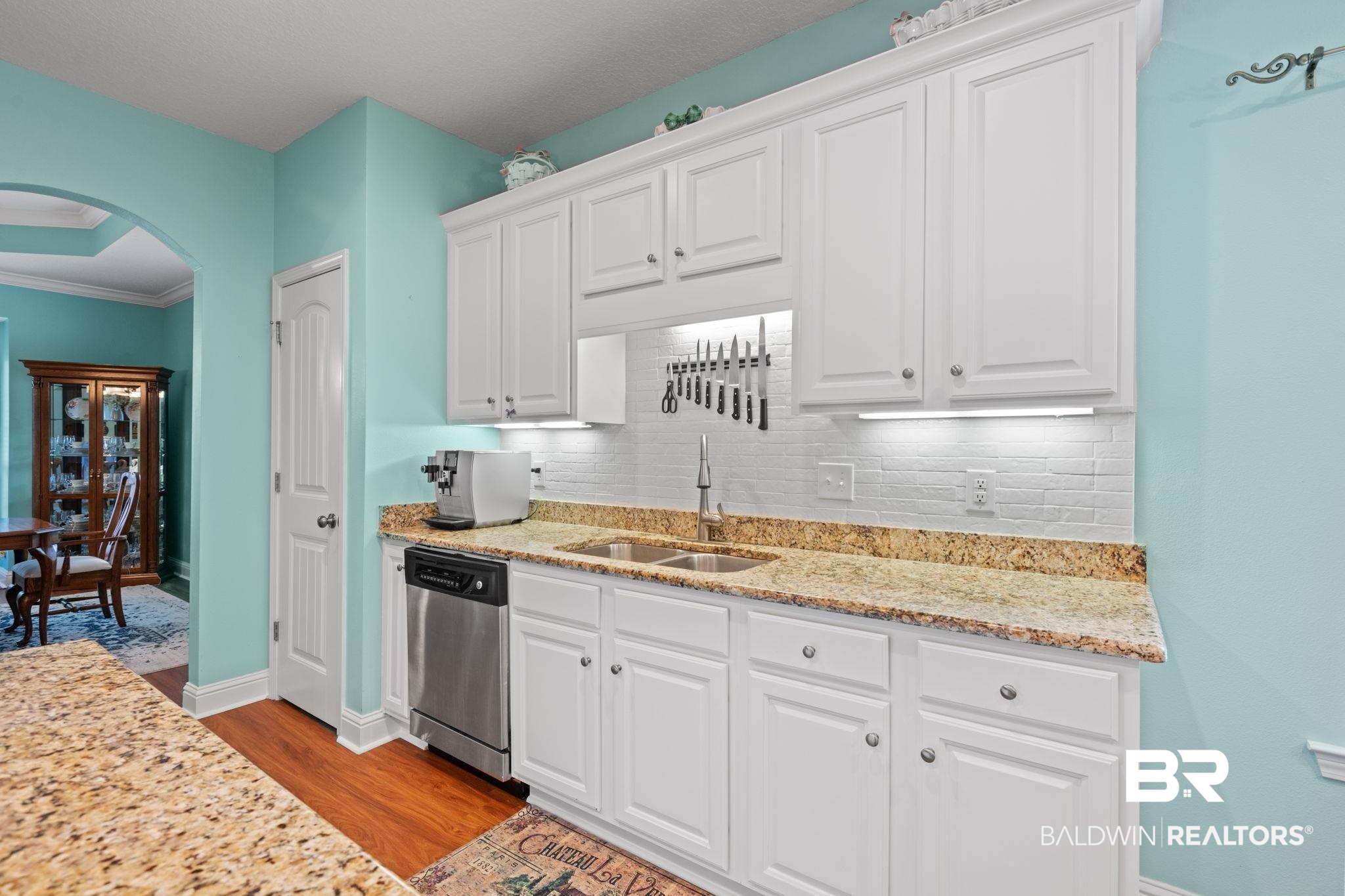 2554 Masters Court Mobile, AL 36618 - Photo 14 of 35 Kitchen with dishwasher, arched walkways, tasteful backsplash, light wood-style floors, and white cabinetry