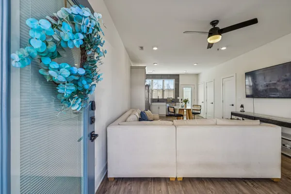 a living room with furniture and a dining table with kitchen view