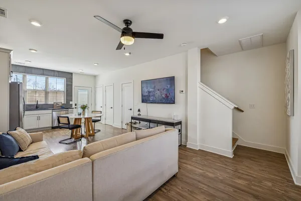 a living room with stainless steel appliances furniture a refrigerator and a view of kitchen