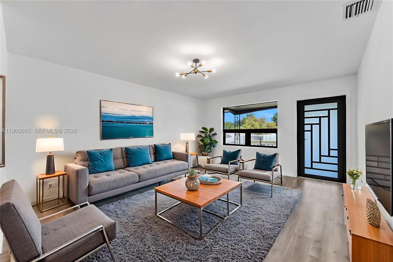 3040 Northwest 96th Street Miami, FL 33147 - Photo 1 of 26 a living room with furniture a rug and a flat screen tv