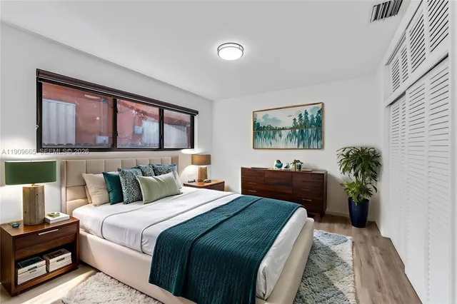 a bedroom with a large bed and a potted plant