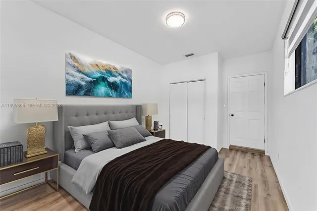 a bedroom with a bed and a painting on the wall