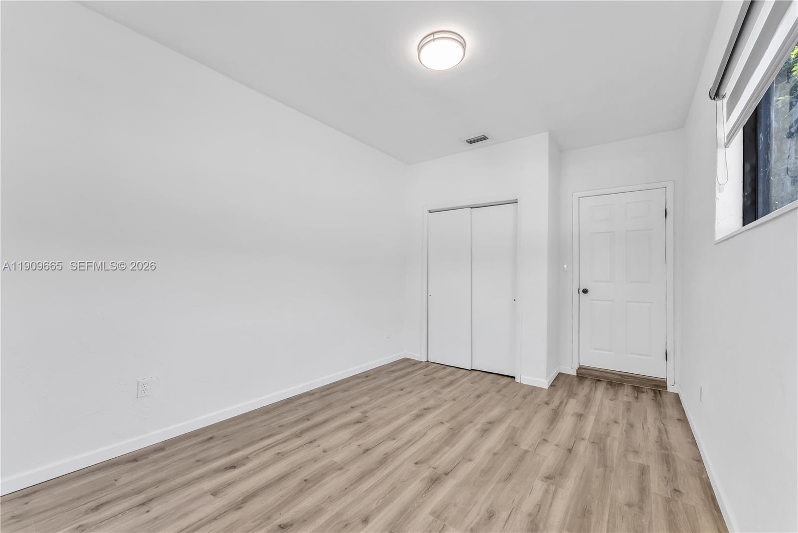 3040 Northwest 96th Street Miami, FL 33147 - Photo 19 of 26 a view of empty room with wooden floor and entryway