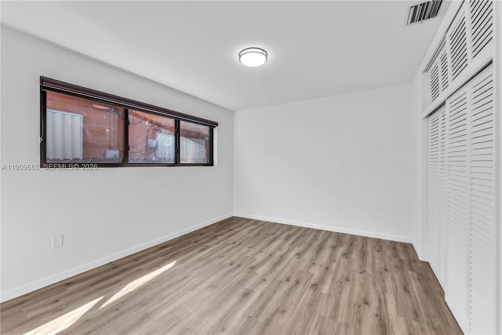 3040 Northwest 96th Street Miami, FL 33147 - Photo 20 of 26 a view of empty room with wooden floor and fan