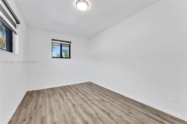 a view of empty room with wooden floor