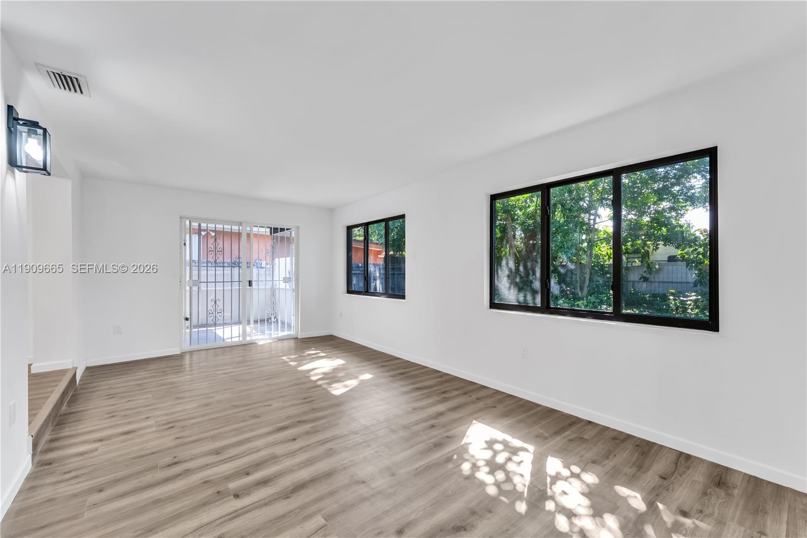 3040 Northwest 96th Street Miami, FL 33147 - Photo 3 of 26 a view of an empty room with wooden floor and a window