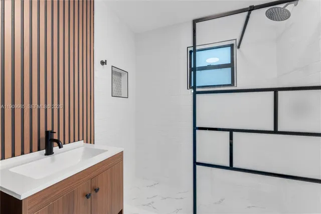 a bathroom with a sink a mirror and shower