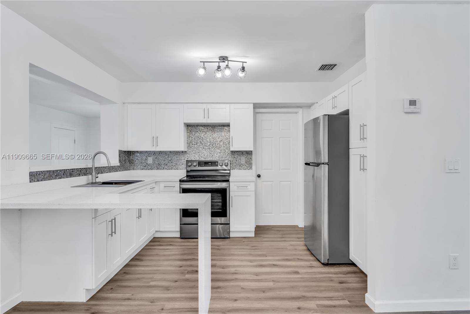 3040 Northwest 96th Street Miami, FL 33147 - Photo 6 of 26 a kitchen with stainless steel appliances a sink stove and refrigerator