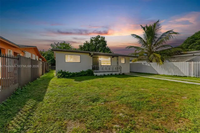 a front view of house with yard and trees around