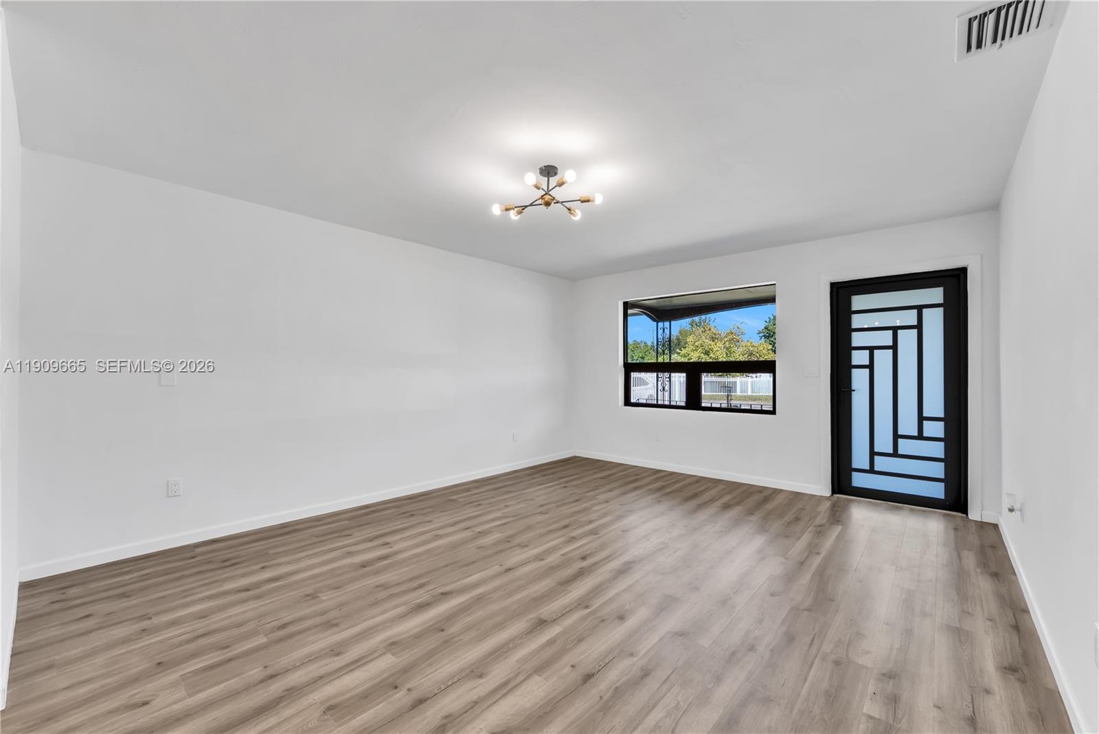 3040 Northwest 96th Street Miami, FL 33147 - Photo 9 of 26 wooden floor in an empty room with a window