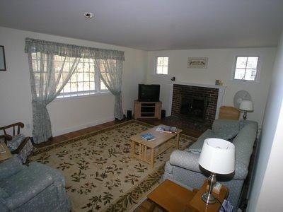 5 Wood Road Dennis Port, MA 02639 - Photo 3 of 7 a living room with furniture a fireplace and a flat screen tv
