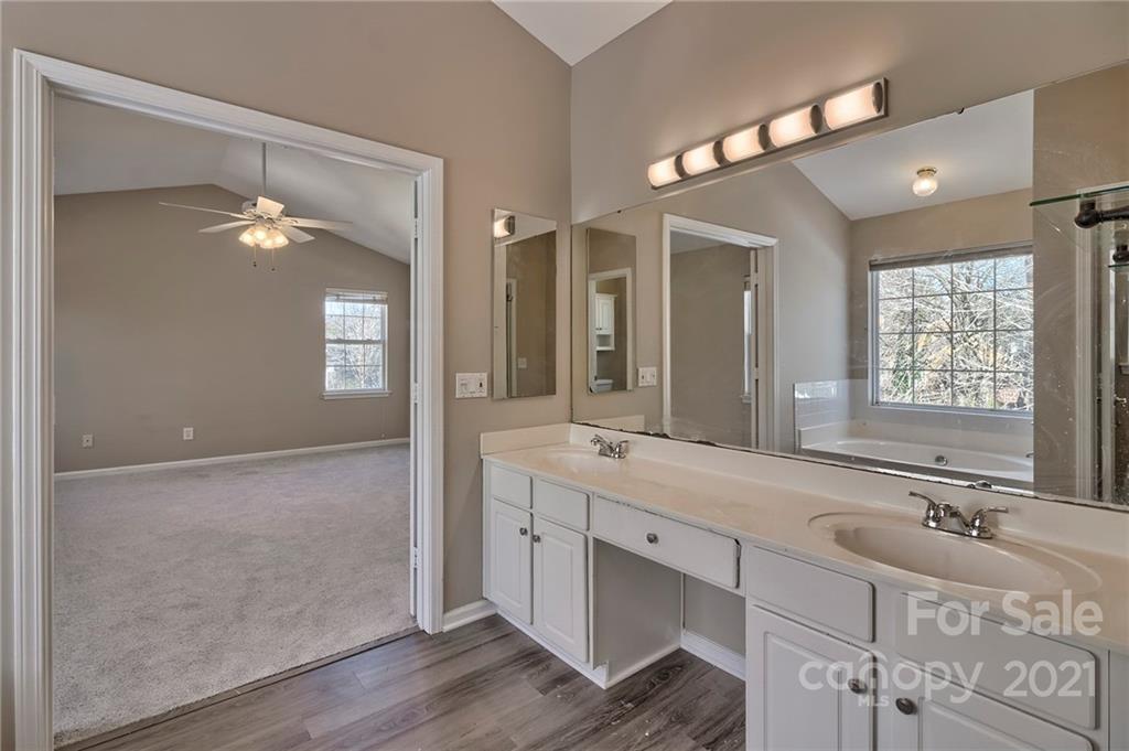 4821 Brownes Ferry Road Charlotte, NC 28269 - Photo 19 of 37 a bathroom with a sink tub and a mirror