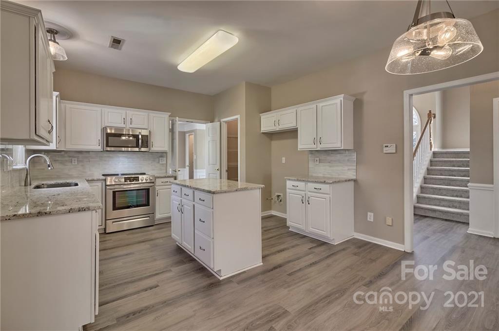 4821 Brownes Ferry Road Charlotte, NC 28269 - Photo 21 of 37 a kitchen with granite countertop white cabinets and stainless steel appliances