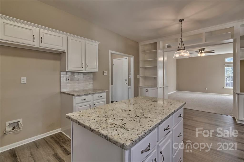 4821 Brownes Ferry Road Charlotte, NC 28269 - Photo 24 of 37 a kitchen with cabinets and chandelier