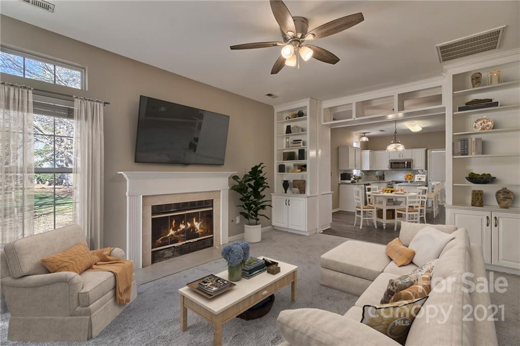 4821 Brownes Ferry Road Charlotte, NC 28269 - Photo 8 of 37 a living room with furniture a fireplace and a flat screen tv