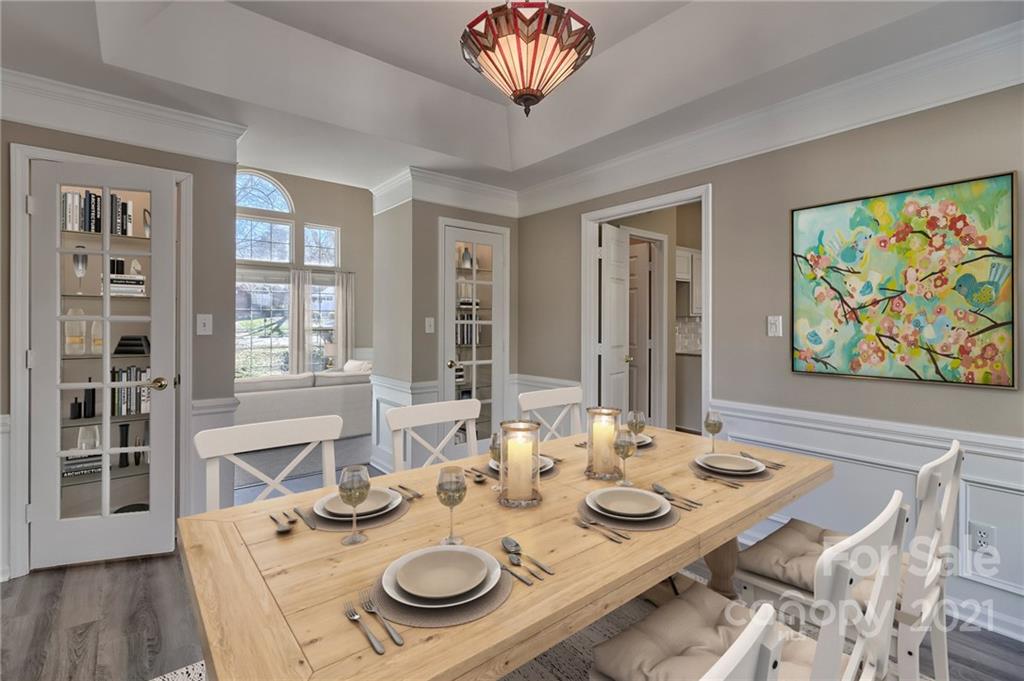 4821 Brownes Ferry Road Charlotte, NC 28269 - Photo 10 of 37 a view of a dining room with furniture a chandelier and wooden floor