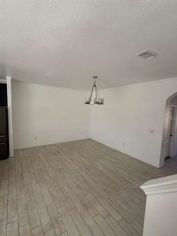a view of a room with wooden floor and white walls