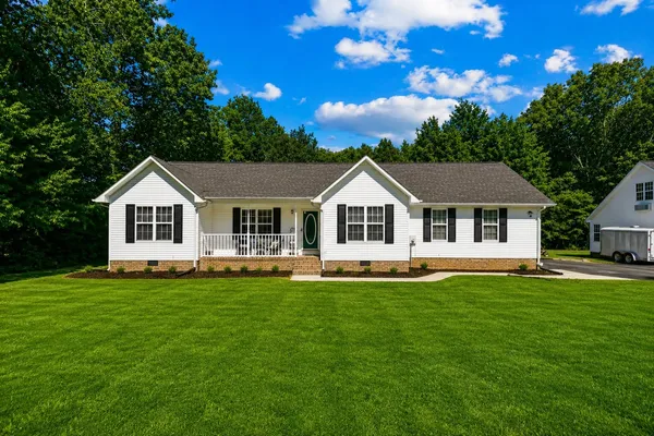 a house with a big yard and wooden fence