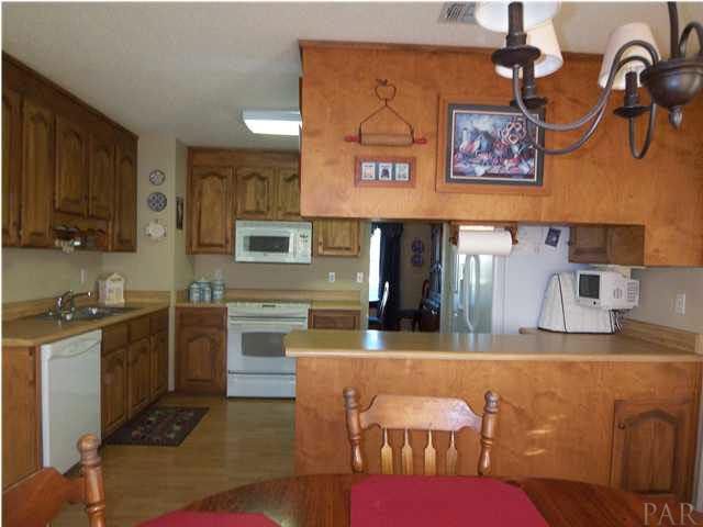 5730 Frank Reeder Road Pensacola, FL 32526 - Photo 9 of 24 Kitchen with an abundant of all wood Birch cabinets and Armstrong laminate flooring. All kitchen appliances will convey. Including Undermount TV