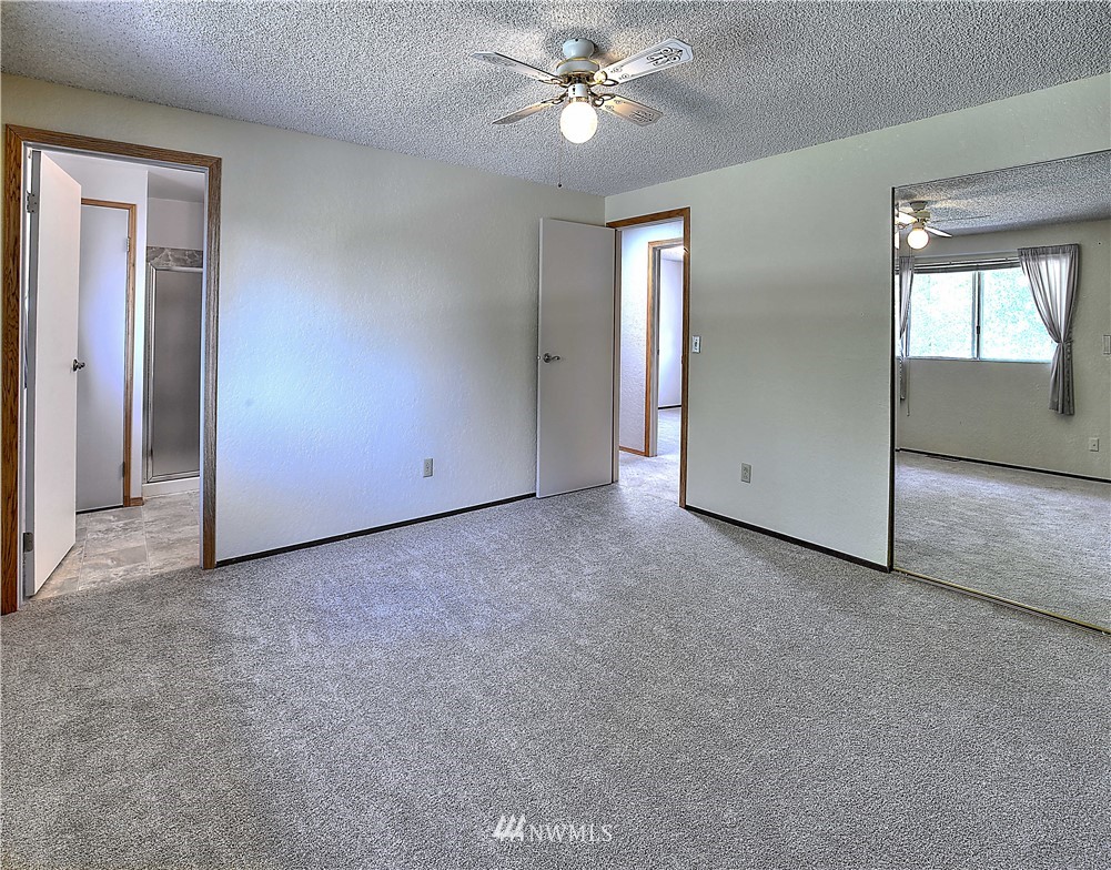 10020 Northeast 204th Street Bothell, WA 98011 - Photo 11 of 30 an empty room with chandelier fan and windows