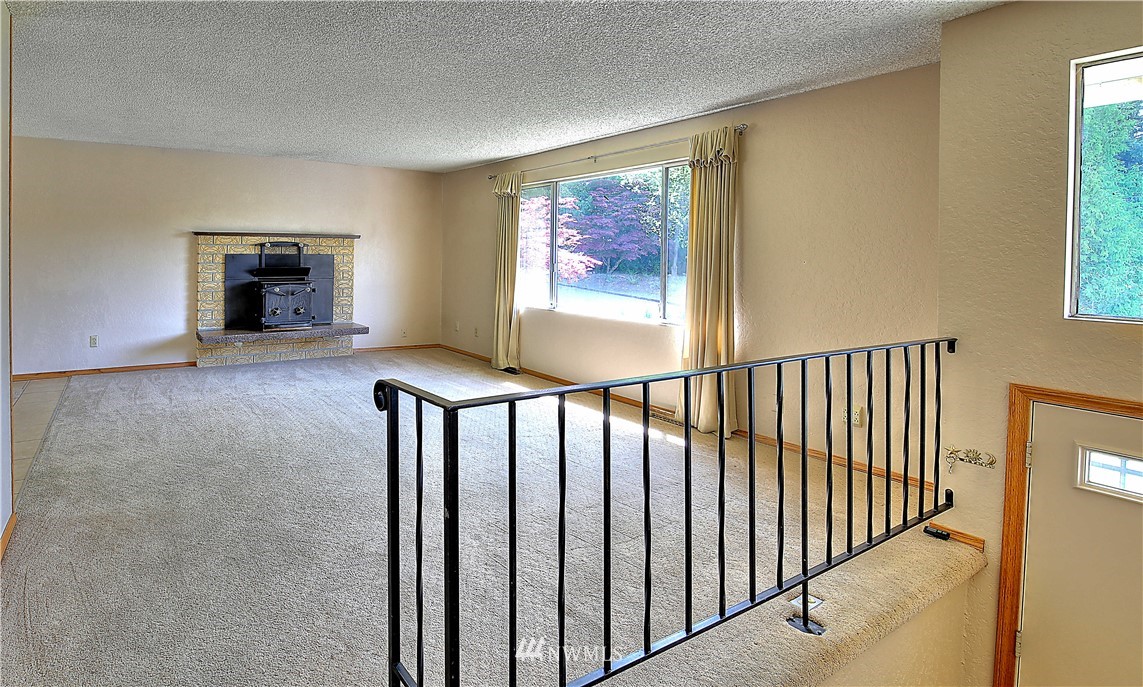 10020 Northeast 204th Street Bothell, WA 98011 - Photo 3 of 30 a view of hallway with wooden floor and fireplace
