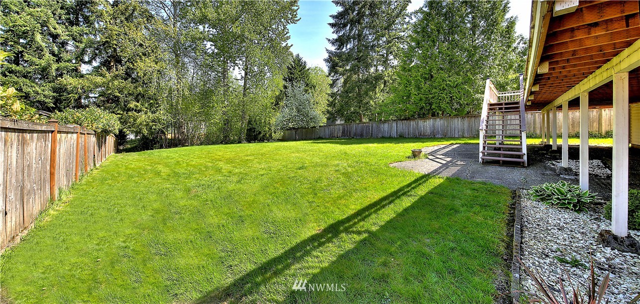 10020 Northeast 204th Street Bothell, WA 98011 - Photo 24 of 30 a view of a backyard with table and chairs and wooden fence