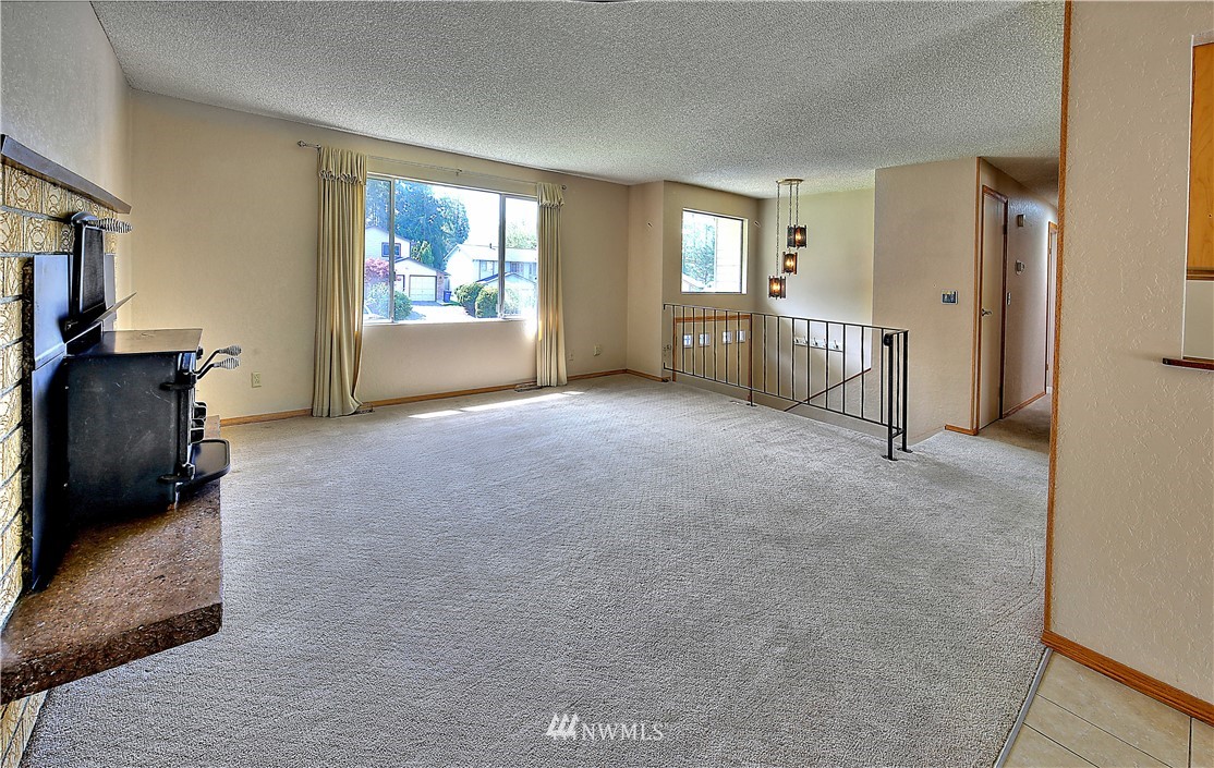 10020 Northeast 204th Street Bothell, WA 98011 - Photo 4 of 30 a view of an empty room with a fireplace and a window
