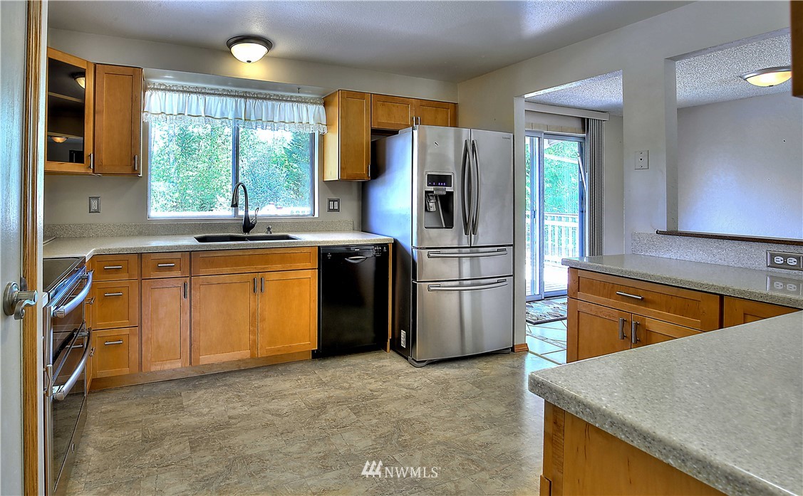 10020 Northeast 204th Street Bothell, WA 98011 - Photo 6 of 30 a kitchen with a sink a stove a refrigerator and a refrigerator