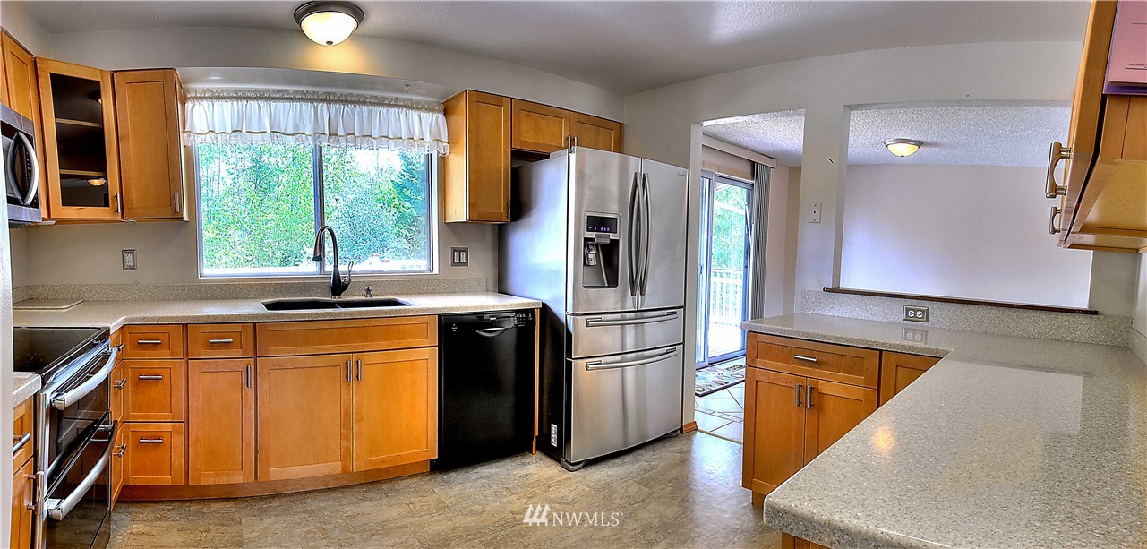 10020 Northeast 204th Street Bothell, WA 98011 - Photo 7 of 30 a kitchen with stainless steel appliances granite countertop a refrigerator a sink and a stove