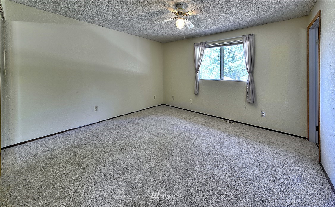 10020 Northeast 204th Street Bothell, WA 98011 - Photo 10 of 30 an empty room with windows and chandelier fan