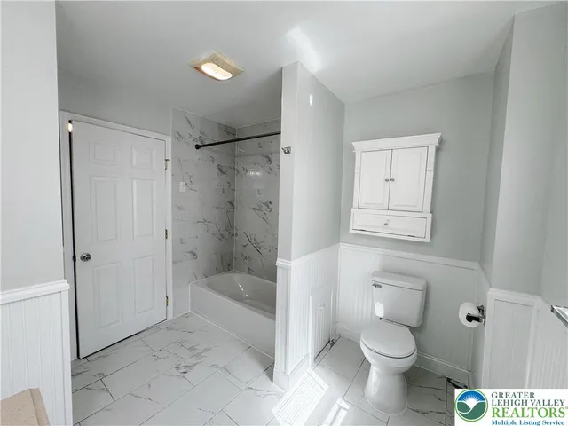 a bathroom with a toilet a sink and shower