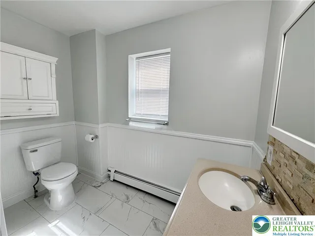 a bathroom with a granite countertop toilet and sink