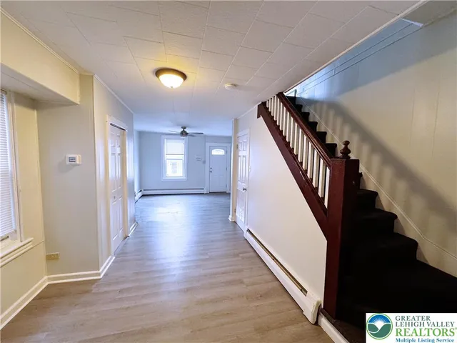 a view of a hallway with wooden floor and staircase