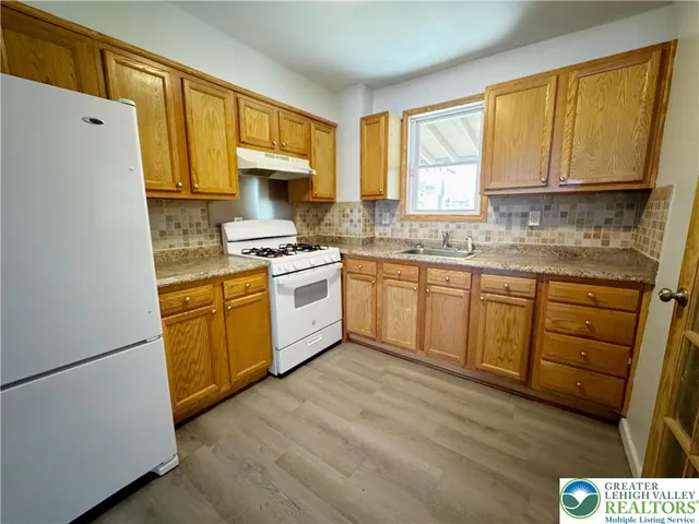 a kitchen with stainless steel appliances granite countertop a stove a sink dishwasher and a refrigerator