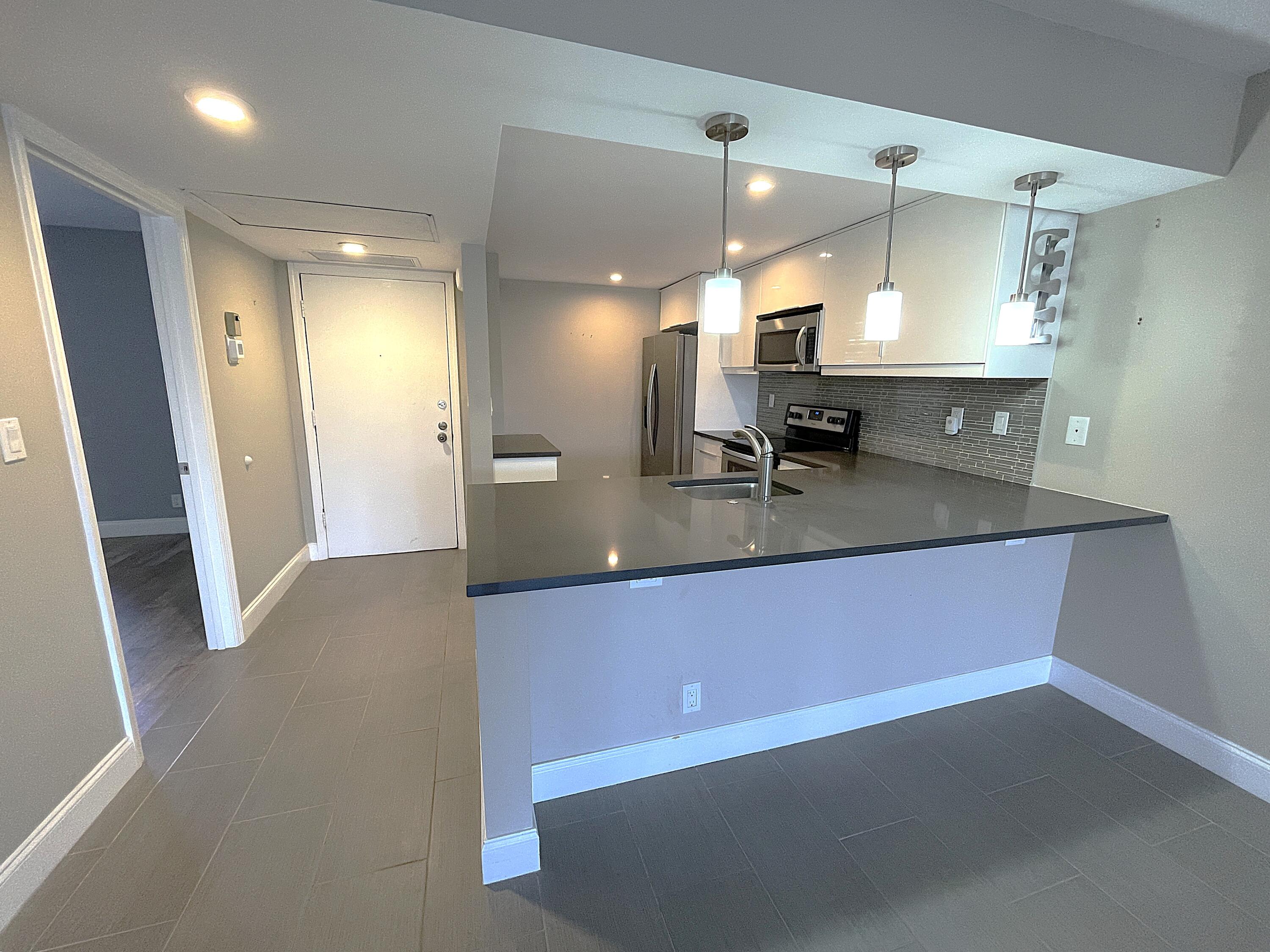 3 Royal Palm Way, Unit 2050 Boca Raton, FL 33432 - Photo 3 of 25 a large kitchen with a large counter top cabinets and stainless steel appliances