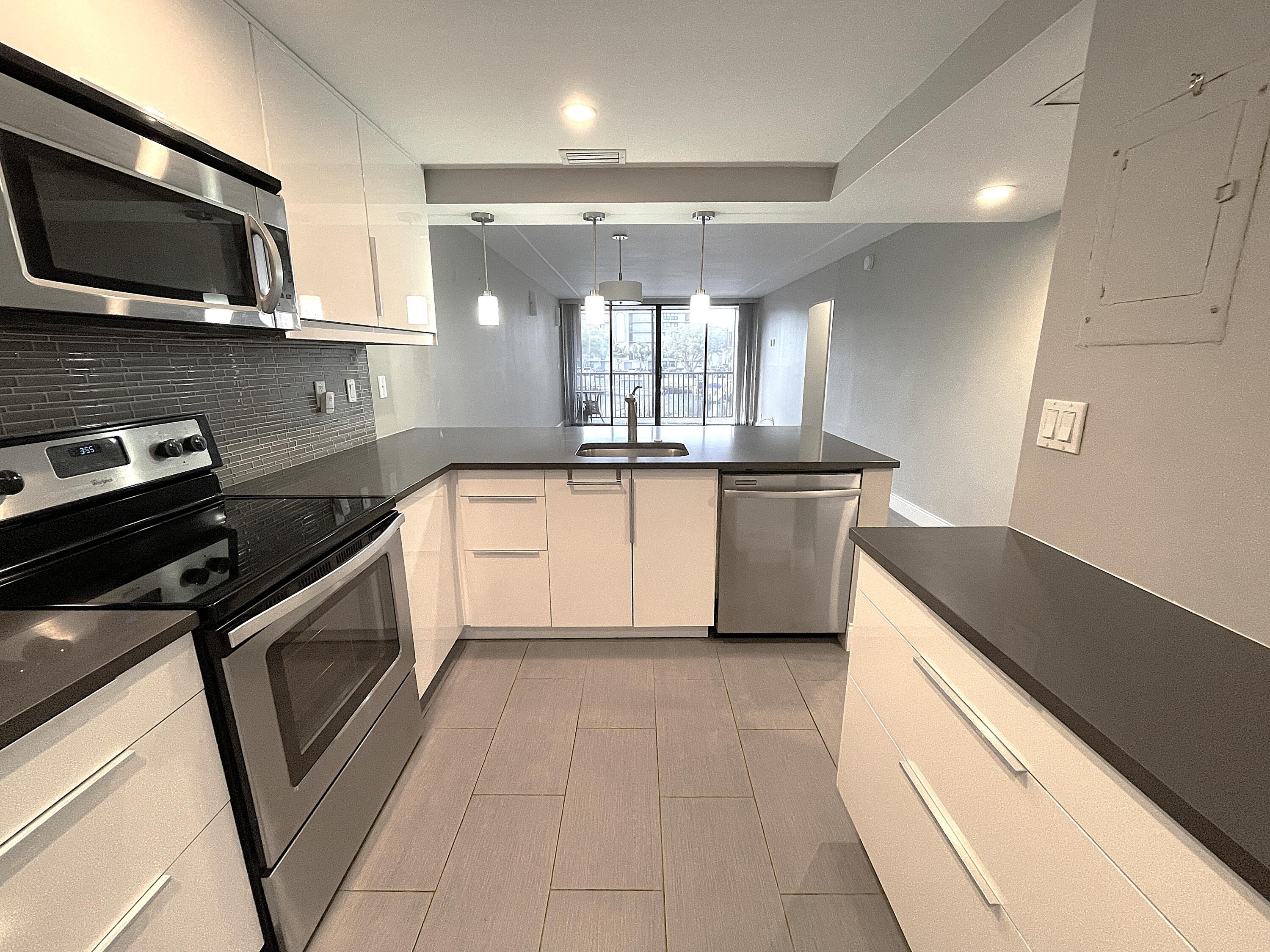 3 Royal Palm Way, Unit 2050 Boca Raton, FL 33432 - Photo 4 of 25 a kitchen with stainless steel appliances granite countertop a stove a microwave and a sink