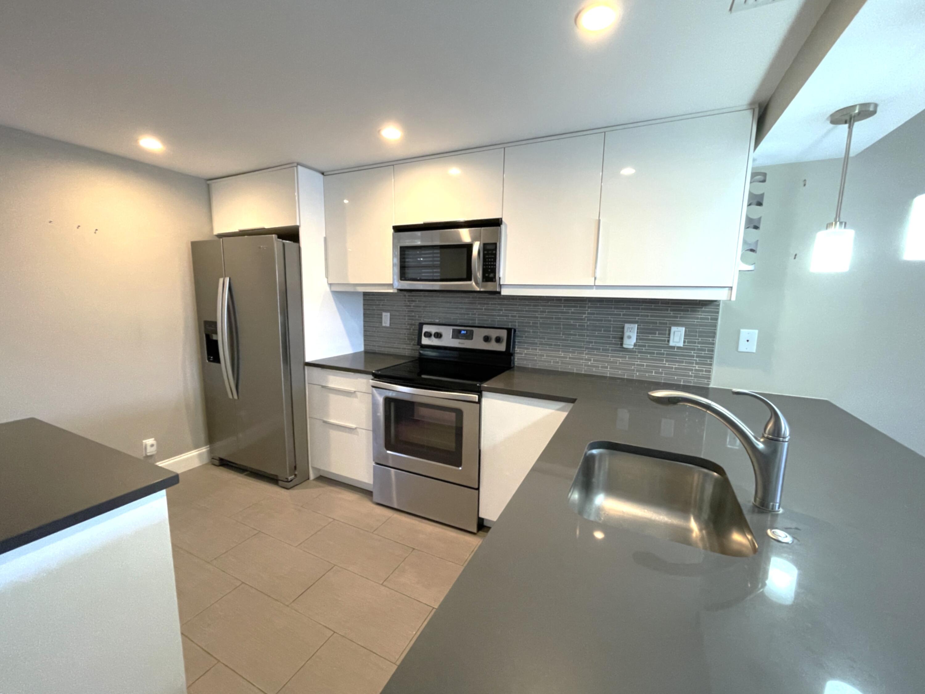 3 Royal Palm Way, Unit 2050 Boca Raton, FL 33432 - Photo 5 of 25 a kitchen with a refrigerator a stove and a sink