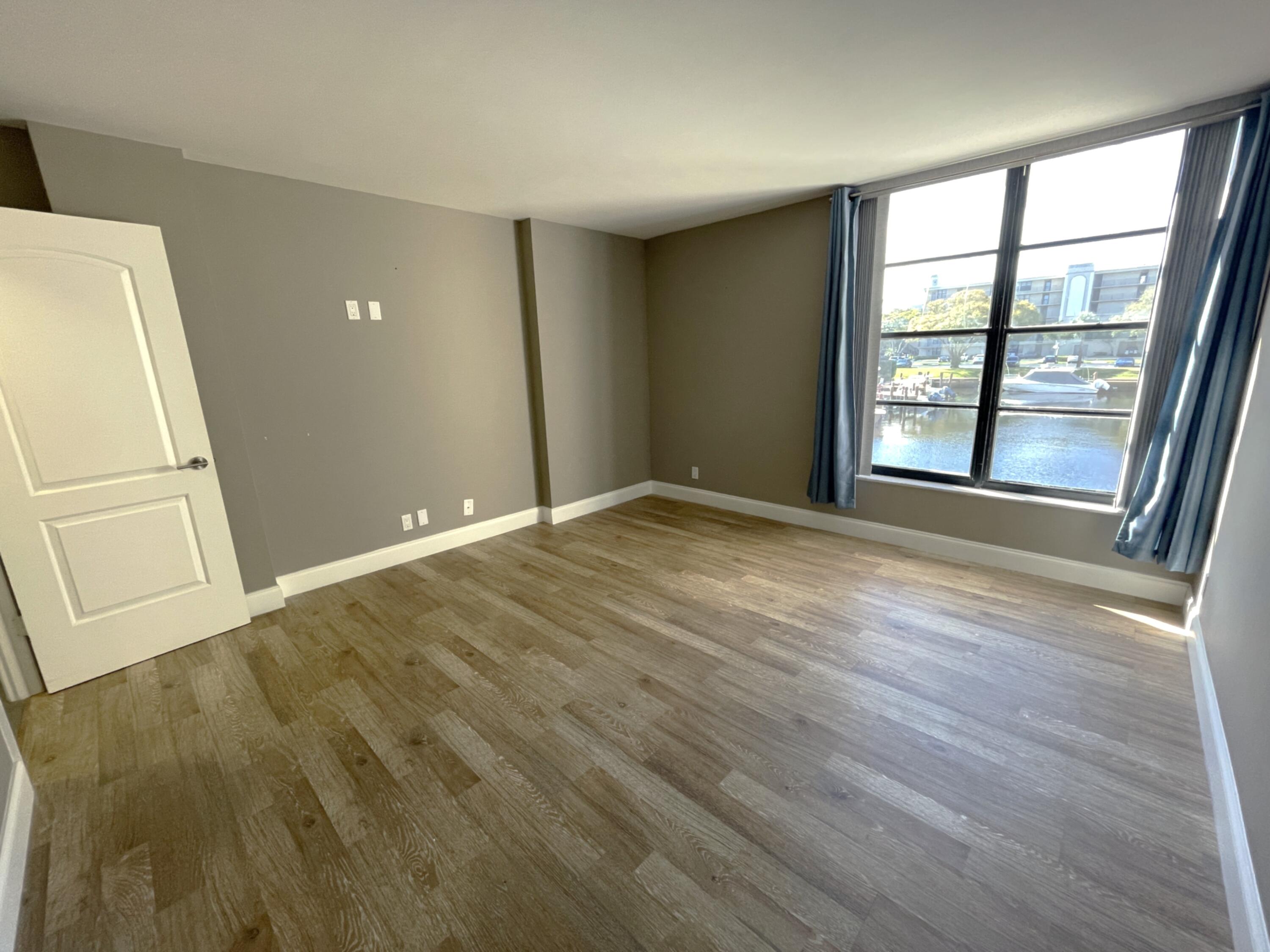 3 Royal Palm Way, Unit 2050 Boca Raton, FL 33432 - Photo 10 of 25 an empty room with wooden floor and windows