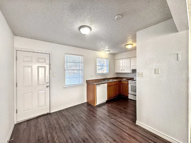 a kitchen with stainless steel appliances kitchen island wooden floors and white walls