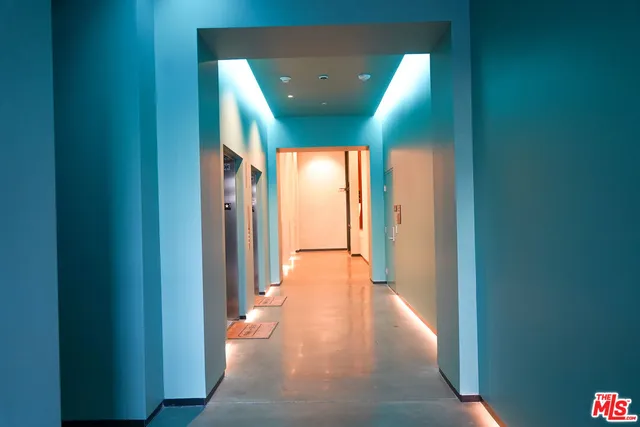 a view of a hallway with white walls and a black white checkered floor